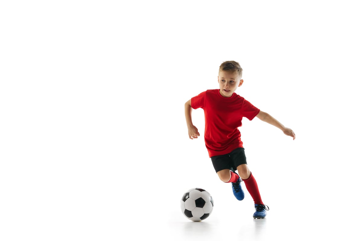 Athletic boy in a sports uniform training hard