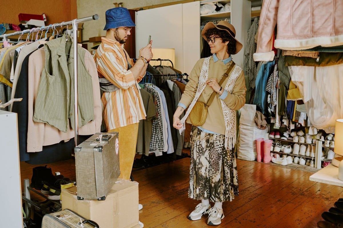 Empire Buddies team member in conversation amidst curated vintage clothing and accessories
