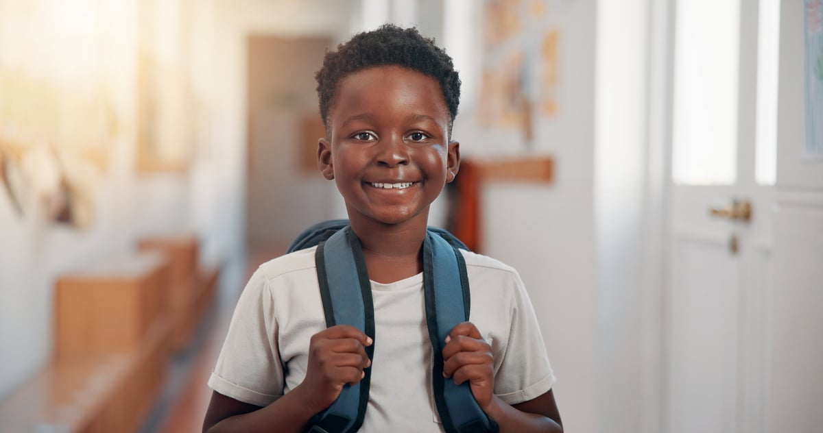 Smiling Black African boy with backpack, ready for school