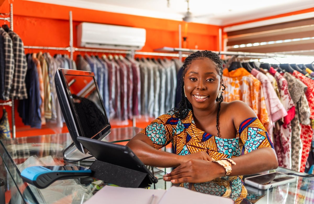 African woman boutique owner at her curated secondhand clothing store