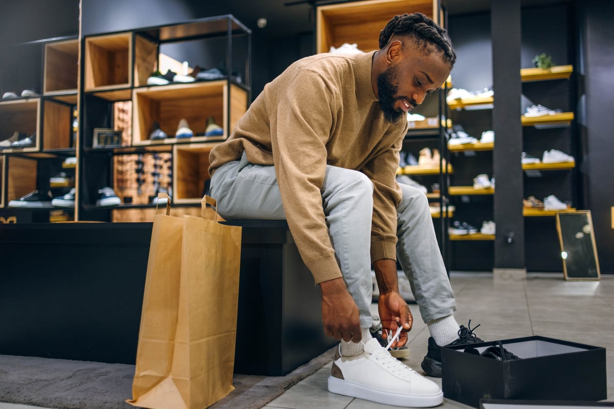 Shopper trying on pre-owned shoes in the curated thrift collection