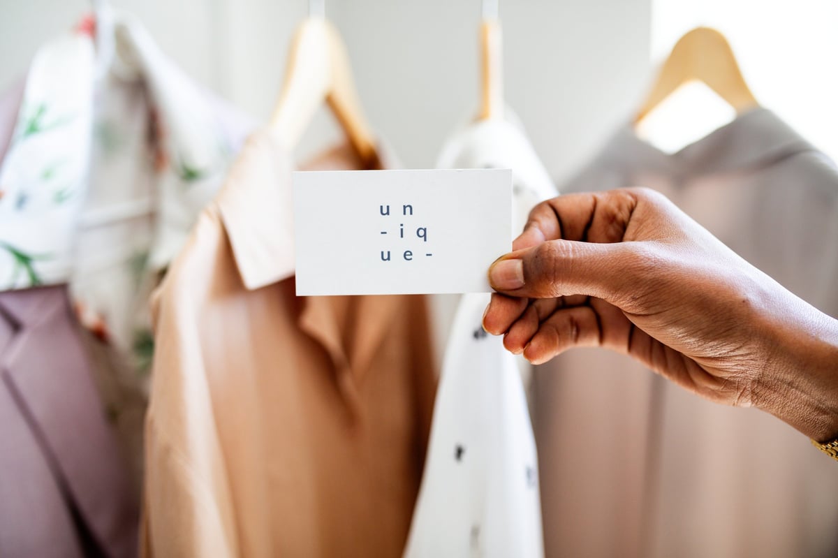 Black woman's hand reaching for a kids clothing rack