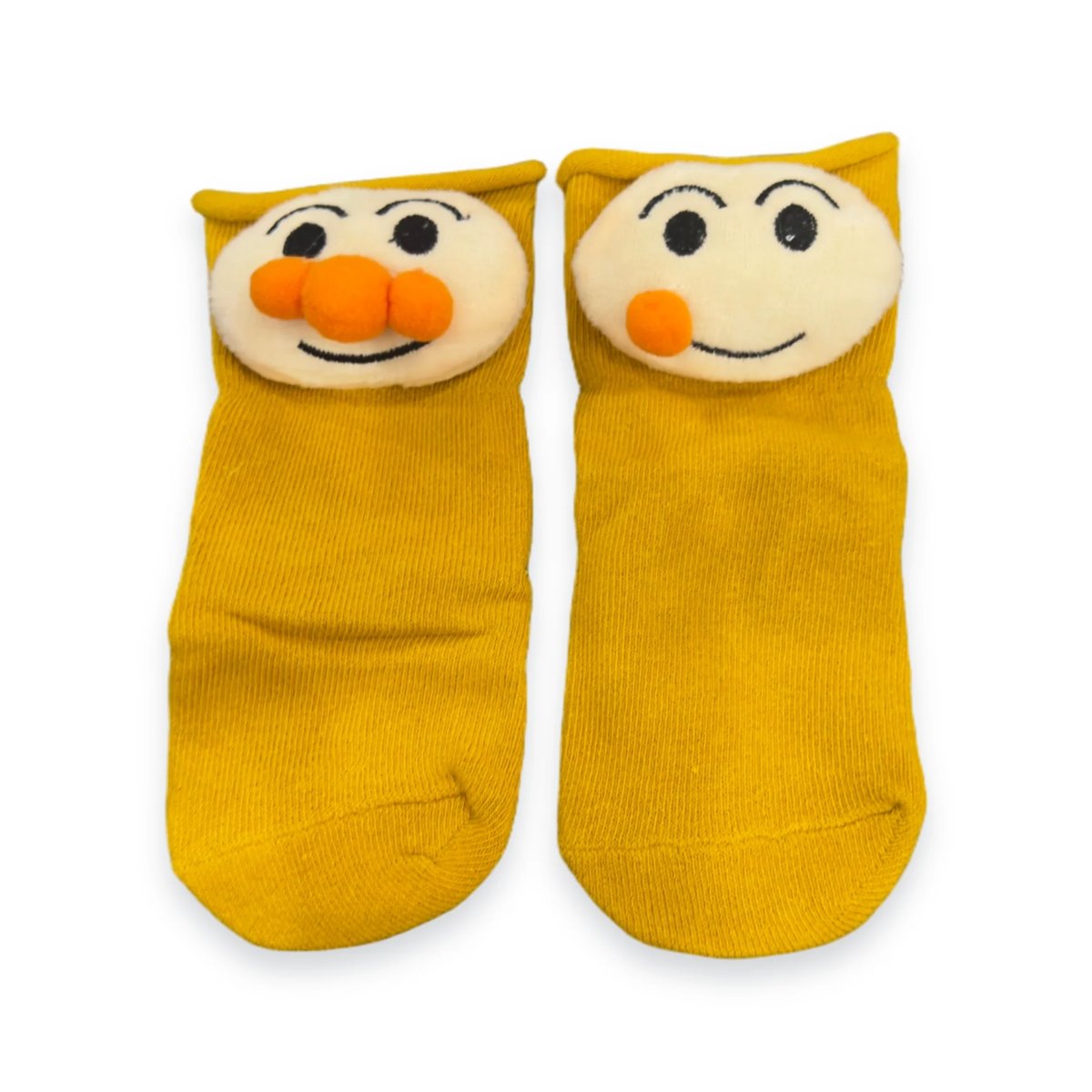 Pair of yellow character socks with smiling faces and orange noses on a white background